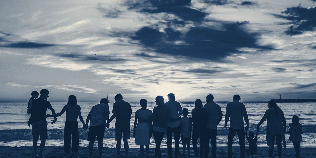 Família reunida de costas ao pôr do sol